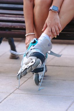 Açık havada bir bankta otururken paten kayan, beyaz çorap giyen ve buz pateni aktivitesine hazırlanan, spor, spor, spor, egzersiz, yaşam tarzı, spor, spor ve spor sunan birini yakından takip edin..