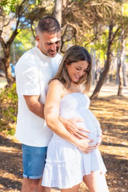 Sevgili çift, hamile karnına dikey şekilde dokunuyor gülümseme, annelik, aile sevgisi, ebeveynlik, hamilelik sevinci, şefkat, birliktelik, gelecekteki hayat, mutluluk, bağlantı..