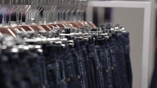 Homem de meia-idade escolhe um jeans na loja — Vídeo de Stock