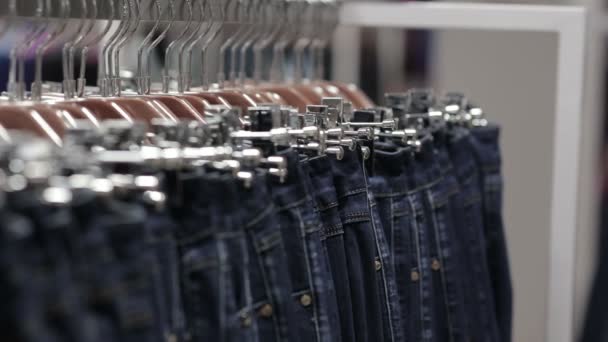 Midaldrende mand vælger en jeans i butikken – Stock-video