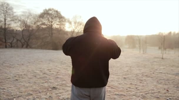 Ember, egy kapucnis, séta a parkban. lassú mozgás — Stock videók
