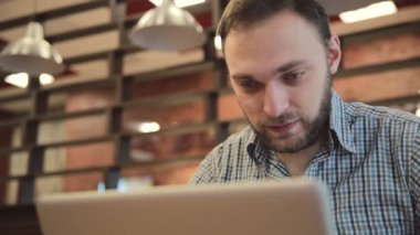 Kafede modern dizüstü bilgisayarda çalışan adam