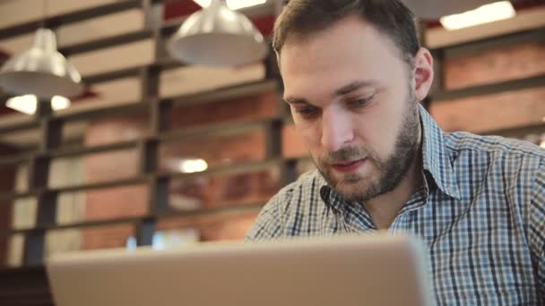 Man som arbetar på modern laptop i café — Stockvideo