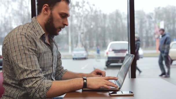 Hombre trabajando en el portátil en la cafetería. estática — Vídeos de Stock