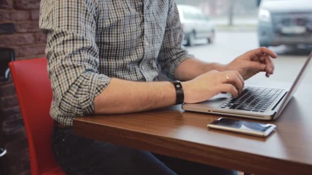 Mains masculines travaillant sur un ordinateur portable dans un café — Video