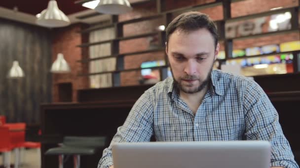 Чоловік працює на ноутбуці в кафе. статичний — стокове відео