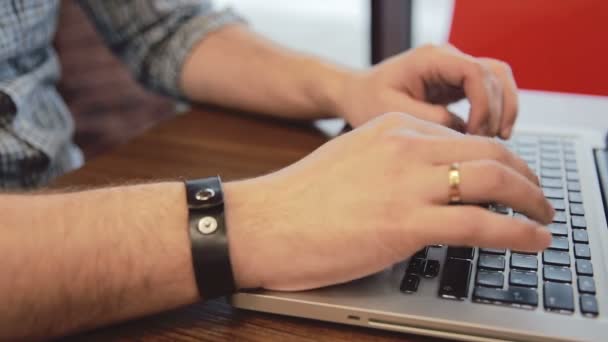 Чоловічі руки працюють на ноутбуці в кафе — стокове відео