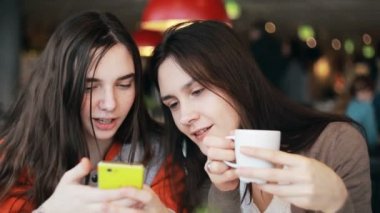 kafede konuşmak smartphone kullanarak iki kız kardeş