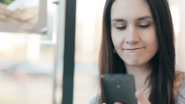 Hermosa mujer usando teléfono inteligente en la cafetería . — Vídeo de stock