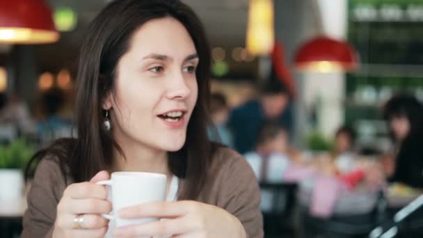 Ragazza bere caffè e parlare con qualcuno — Video Stock
