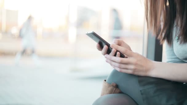 Las manos de la mujer mensajes de texto, utilizando el teléfono inteligente en la cafetería . — Vídeo de stock