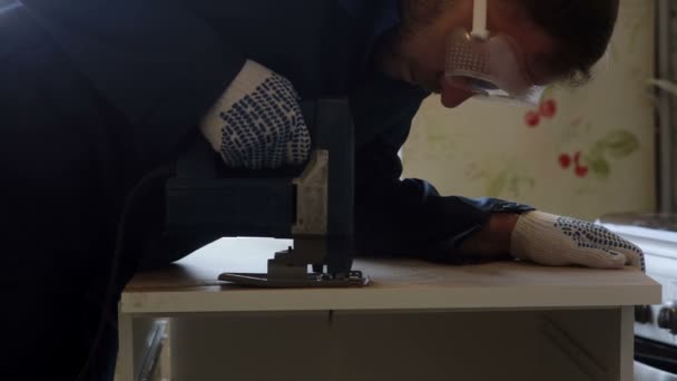 Male worker using the jigsaw. Furniture assembly. — Stock Video