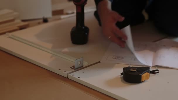 Adam işçi mobilya yönergesi kullanarak birleştirir — Stok video