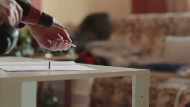 Adam mobilya bir güç tornavida kullanarak birleştirir — Stok video