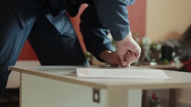 Mannelijke werknemer assembleert onderdelen van meubilair. — Stockvideo