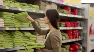 Genç kadın havlu süpermarkette seçer.