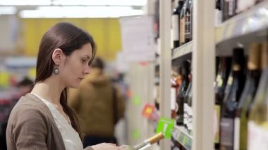 Kadın şarap raflar içinde belgili tanımlık stok seçer.
