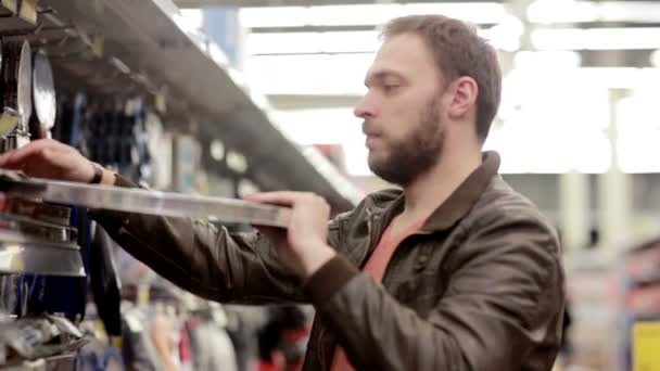 Homem escolhe artigos esportivos na loja — Vídeo de Stock