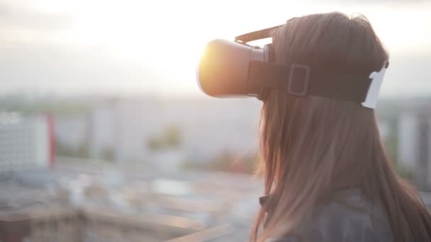 Женщина использует очки виртуальной реальности на крыше — стоковое видео