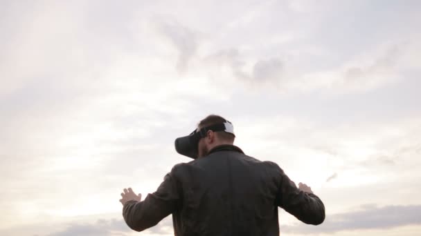 Hombre utiliza unas gafas de realidad virtual contra el cielo — Vídeo de stock