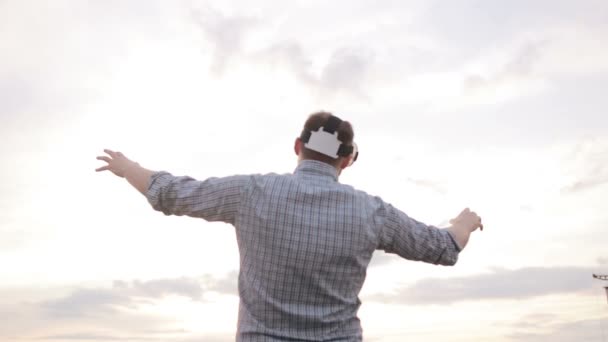 Homem usa uma realidade virtual óculos contra o céu — Vídeo de Stock