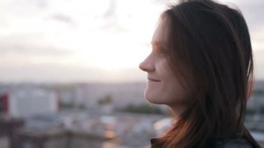 Kız çatıda günbatımında ayakta