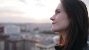 Kız çatıda günbatımında ayakta