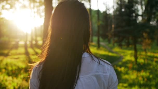 Frau, die bei Sonnenuntergang im Wald spaziert. Zeitlupe — Stockvideo