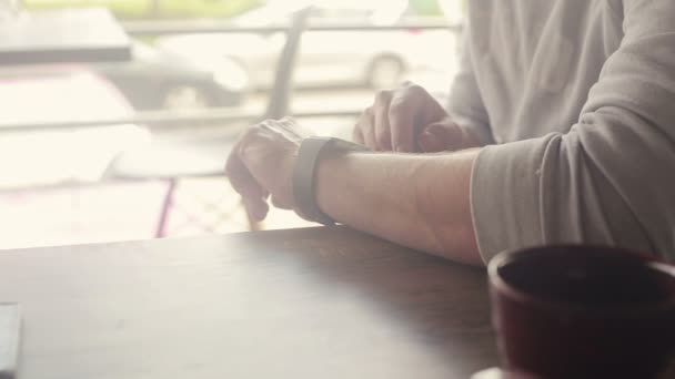 Man met smartwatch zitten in Cafe in stad — Stockvideo