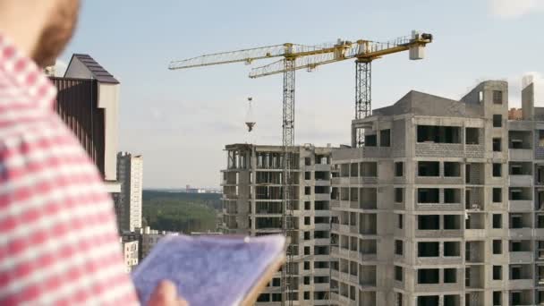 Ingenieur schaut sich Projekt auf Baustelle an — Stockvideo