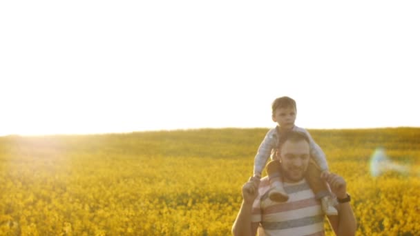 Padre lleva a su hijo sobre sus hombros. Lento mo — Vídeos de Stock