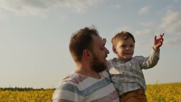 Vader spelen met zoon bij veld. Slow motion — Stockvideo