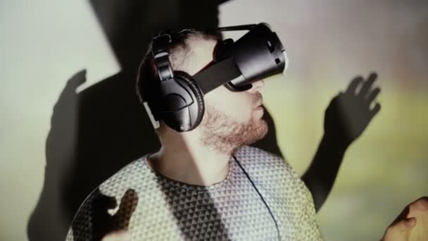 Un homme utilisant un casque VR sous les projecteurs — Video