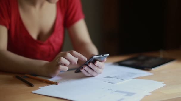 Mujer comprueba cuentas usando un teléfono inteligente en casa — Vídeo de stock