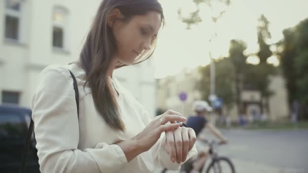 Kvinnan använder smartwatch stående i gamla staden långsamma mo — Stockvideo