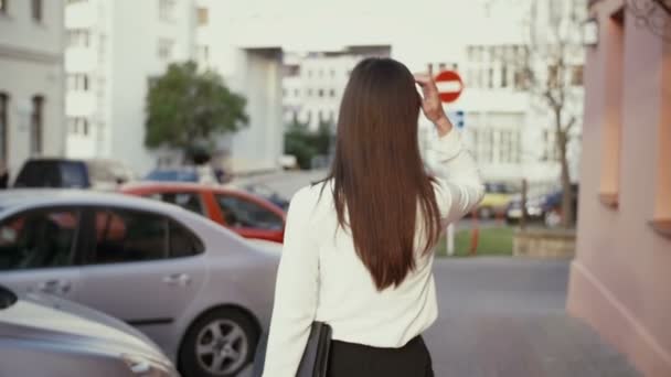 Vrouw wandelen in de oude stad bij zonsondergang. slow mo — Stockvideo