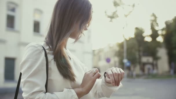 Kvinnan använder smartwatch stående i gamla staden långsamma mo — Stockvideo