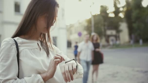 Vrouw gebruikt smartwatch staande in de oude stad langzame mo — Stockvideo