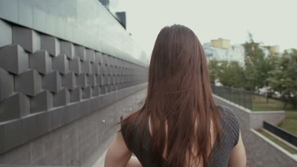 Sexy Geschäftsfrau steht auf einer Brücke mit Blick auf die Straße, Steadicam-Aufnahme. Langsames Wachstum — Stockvideo