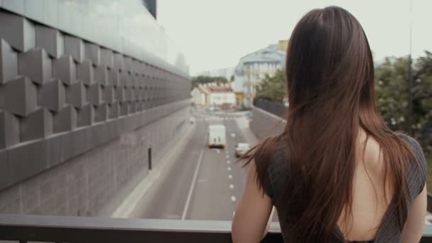 Sexy obchodní žena stojící na mostě s výhledem na silnici, střela statickou. pomalá mo — Stock video