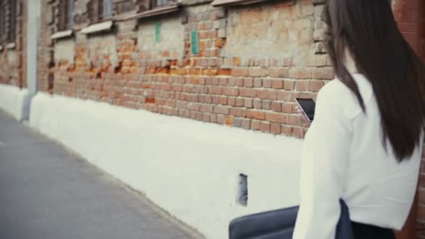 Woman uses smartphone walking in old city. slow mo — 비디오