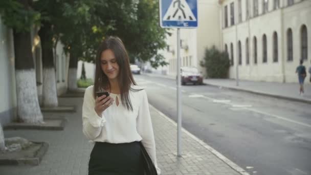 Woman uses smartphone walking in old city. slow mo — Stock video