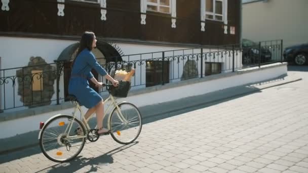 Menina feliz em um vestido de ciclismo e explorando a cidade, câmera lenta, steadicam tiro — Vídeo de Stock