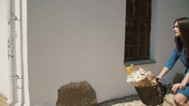 Mutlu güzel esmer kız yaz aylarında sokak dönüm köşesinde bir bisikletsürme, yavaş mo, steadicam atış