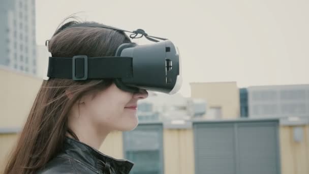 Mujer morena chica con el pelo ondulado utiliza unas gafas de realidad virtual en el techo. 4k — Vídeos de Stock