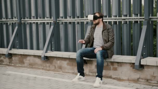 Barbudo atractivo hombre utiliza gafas de realidad virtual en el techo, se quita las gafas y se aleja. 4k — Vídeo de stock