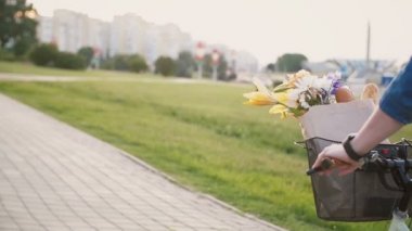 Kollarını ve bacaklarını treadling ve giyen yaz Ayakkabı ve elbise, yavaş mo, steadicam Bisiklete binmek tanımlanamayan kız vurdu