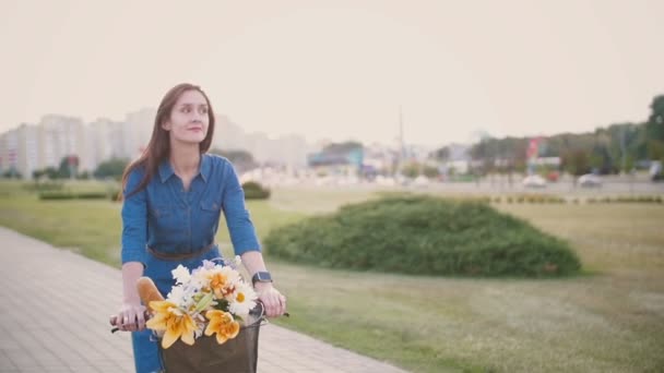 Menina sorridente feliz em um vestido de ciclismo e explorar a cidade, câmera lenta, steadicam tiro — Vídeo de Stock