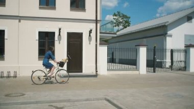İnsanlar yavaş mo, steadicam vurdu tarafından yürürken yakınındaki eski binalar Bisiklete binmek bir esmer kız yan görünüm