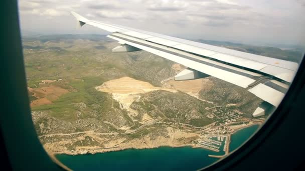 Uçan bir uçağın penceresinden yeryüzünde havadan görünümü — Stok video